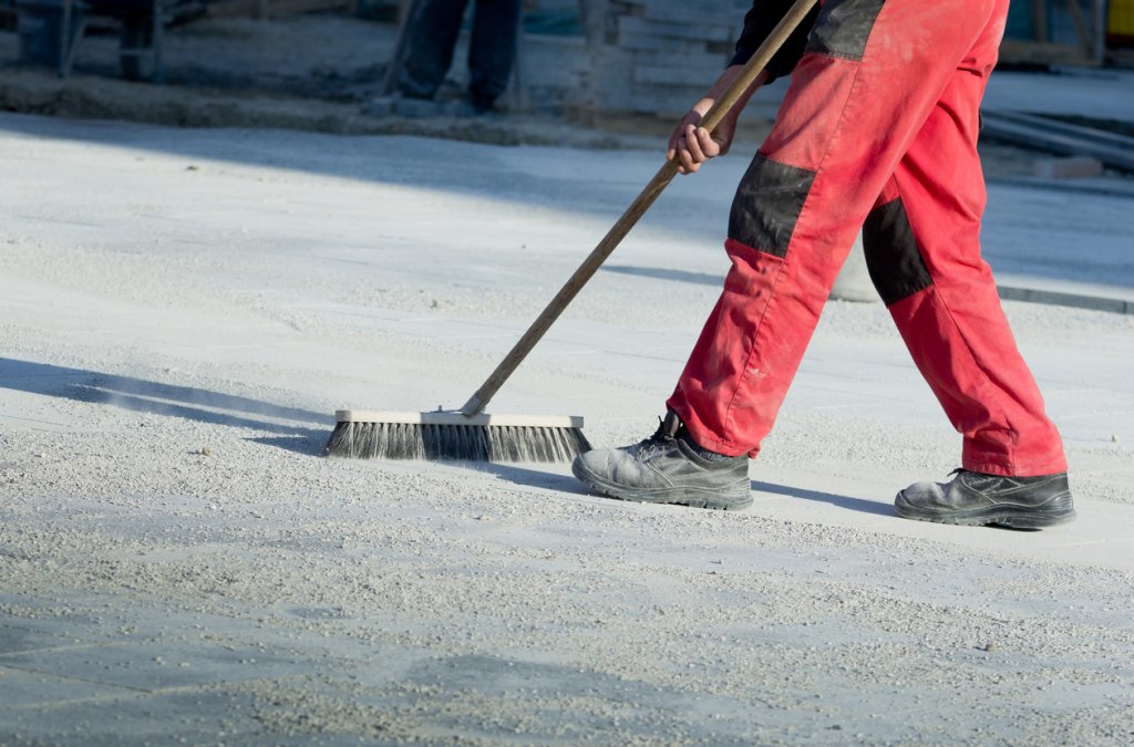 Housekeeper sweeping construction jobsite.